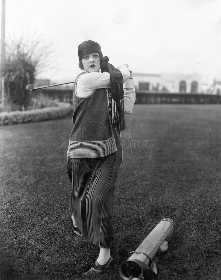 Donna che gioca golf (tutte le persone rappresentate non sono vivente più lungo e nessuna proprietà esiste Garanzie del fornitore immagini stock libere da diritti Donna che gioca golf (tutte le persone rappresentate non sono vivente più lungo e nessuna proprietà esiste Garanzie del fornitore immagini stock libere da diritti
