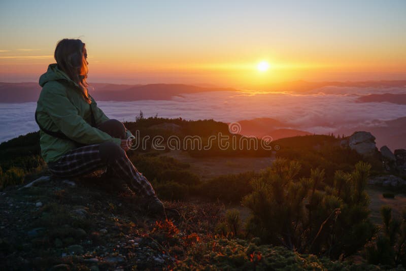 Donna che gode dell'alba nelle montagne immagine stock Donna che gode dell'alba nelle montagne immagine stock