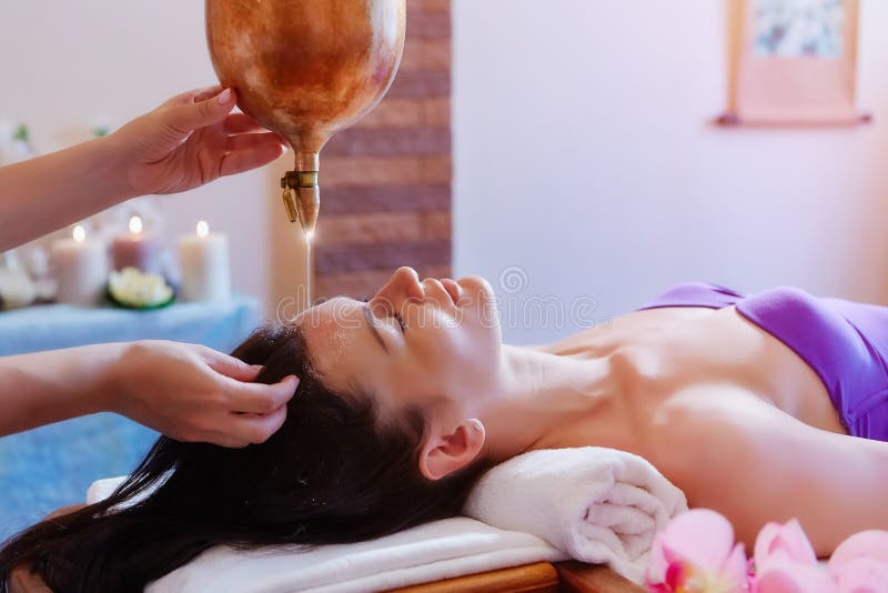 Donna che gode di un trattamento di massaggio dell'olio di Ayurveda in una stazione termale