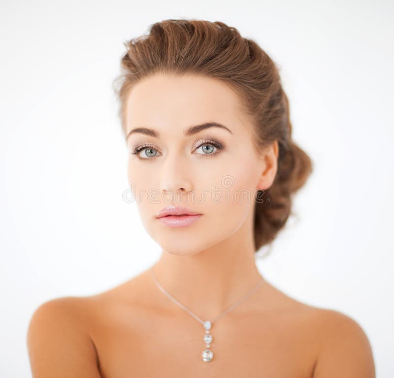 Donna che indossa il pendente brillante del diamante fotografie stock Donna che indossa il pendente brillante del diamante fotografie stock