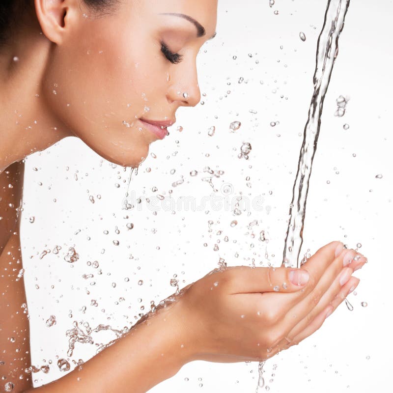 Closeup portrait of a beautiful woman washing her clean face with water. Closeup portrait of a beautiful woman washing her clean face with water