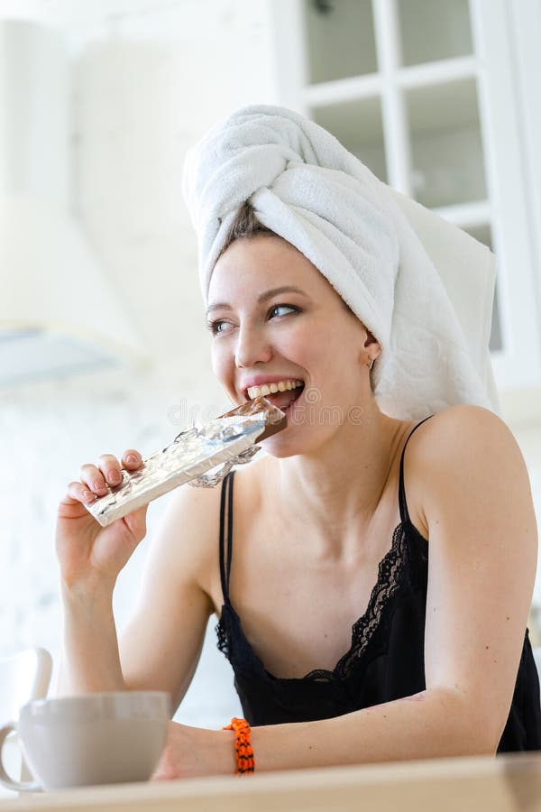 Donna che mangia cioccolato e che gode dopo la conservazione della dieta Pasto dell'imbroglione immagine stock libera da diritti Donna che mangia cioccolato e che gode dopo la conservazione della dieta Pasto dell'imbroglione immagine stock libera da diritti