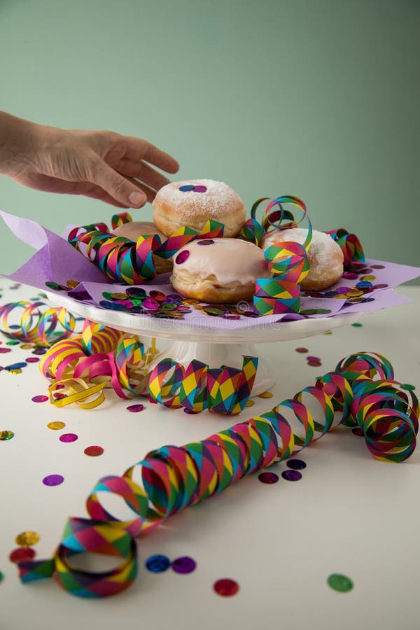 Donna che mangia le ciambelle tedesche tradizionali di Pfannkuchen Krapfen del berlinese per celebrare vigilia year dei nuovi o immagini stock Donna che mangia le ciambelle tedesche tradizionali di Pfannkuchen Krapfen del berlinese per celebrare vigilia year dei nuovi o immagini stock