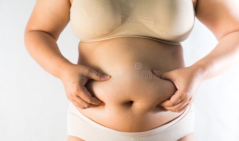 Donna che misura il suo grasso della pancia immagine stock Donna che misura il suo grasso della pancia immagine stock