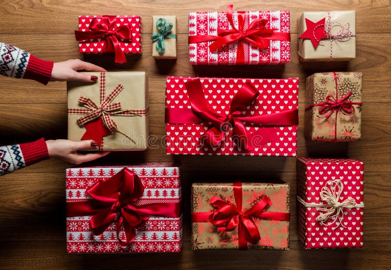Donna che organizza i regali di Natale d'annata beautifuly avvolti su fondo di legno fotografie stock Donna che organizza i regali di Natale d'annata beautifuly avvolti su fondo di legno fotografie stock