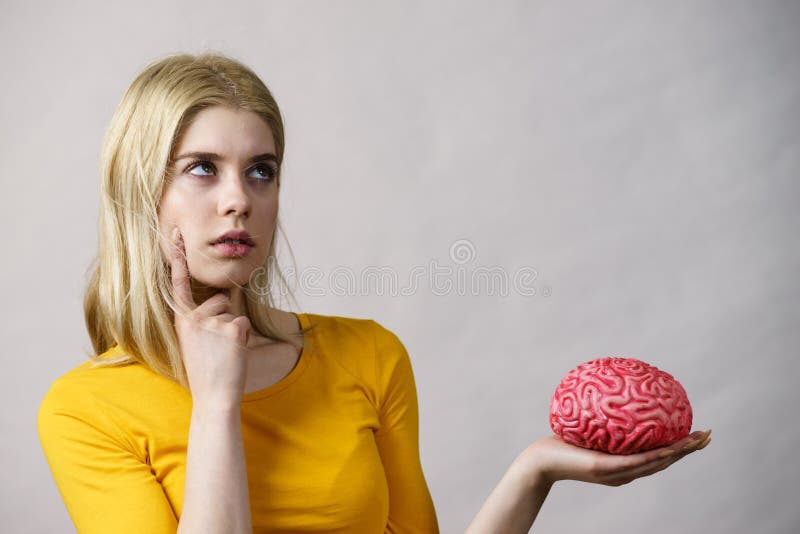 Donna che pensa tiene in mano un cervello fotografia stock libera da diritti