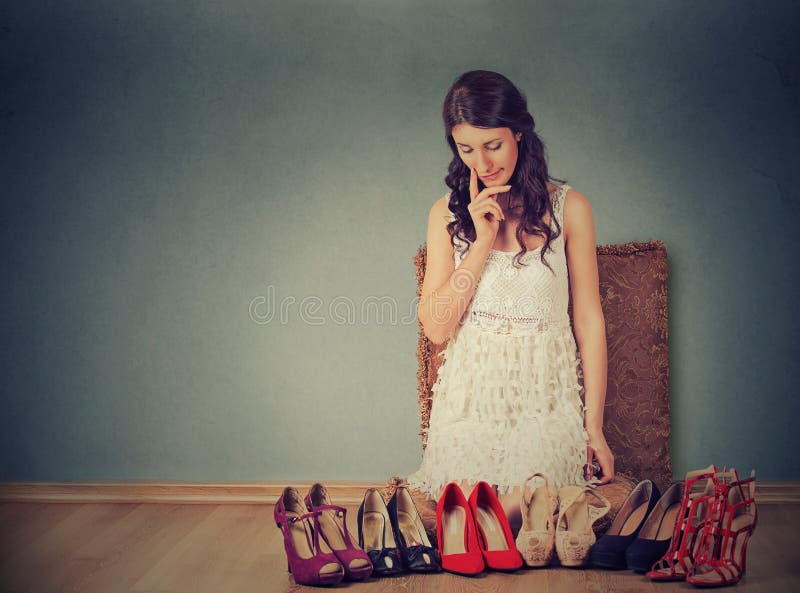 Donna che prende le decisioni che selezionano le giuste paia delle scarpe del tacco alto