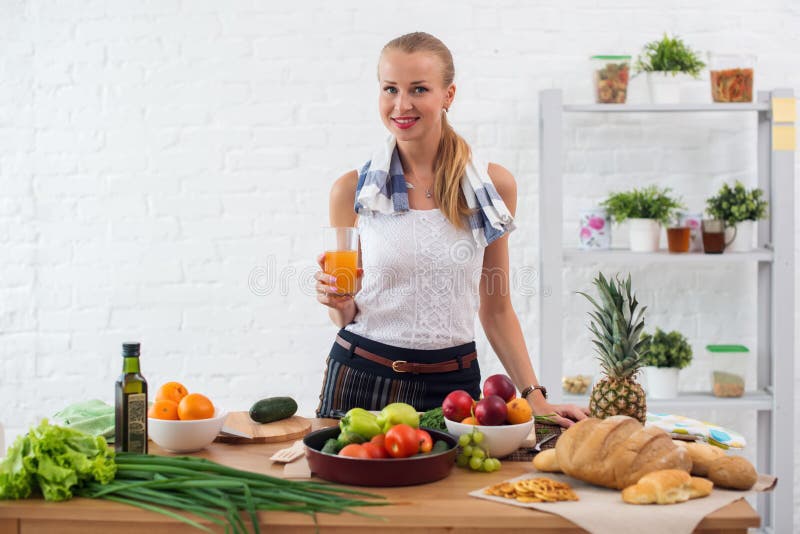 Donna che prepara cena in una cucina, concetto bevente del succo cucinante, stile di vita culinario e sano