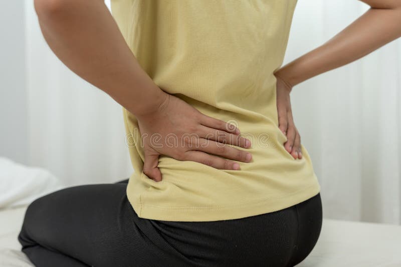 Donna che regge la schiena in posizione inferiore e che soffre di dolore insopportabile salute e problemi mal di schiena cronico m fotografia stock