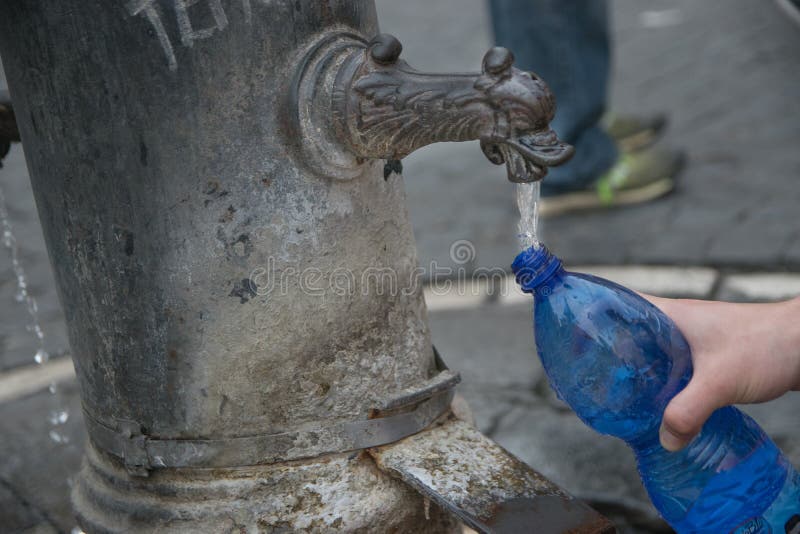 Si Riempie D Acqua Calda Bottiglia Di Riempimento Dall'acqua Di Fonte Fotografia Stock