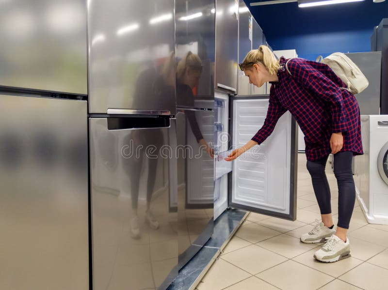 donna che sceglie nuovo frigorifero nel deposito di elettrodomestici fotografie stock donna che sceglie nuovo frigorifero nel deposito di elettrodomestici fotografie stock