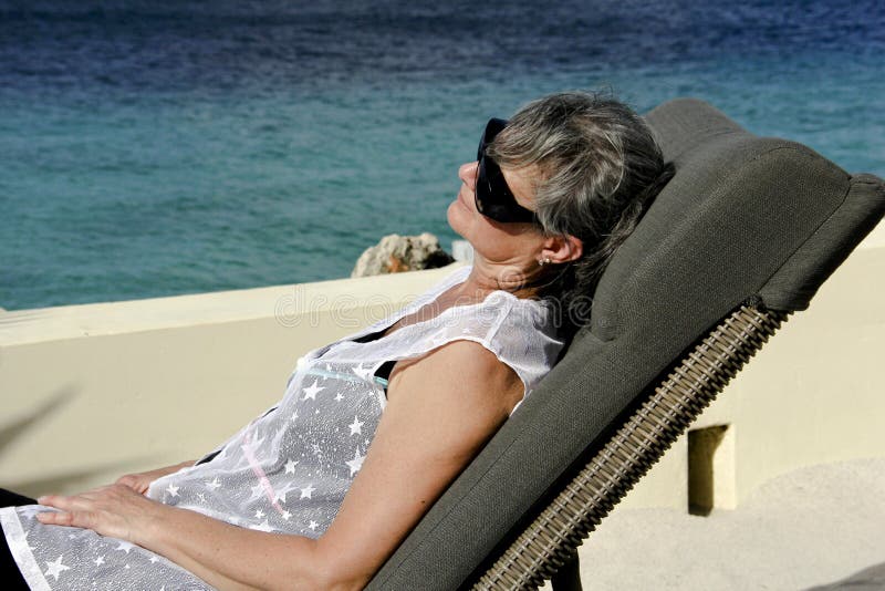 Donna che si distende su una spiaggia tropicale fotografia stock Donna che si distende su una spiaggia tropicale fotografia stock