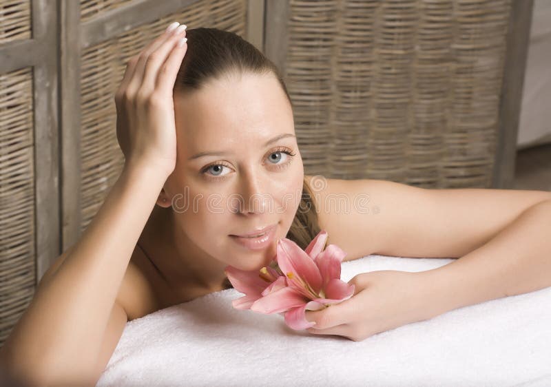 Donna che si rilassa sull'asciugamano in bagno di legno alla moda con i fiori, cura di pelle organica, hotel di lusso della stazi immagini stock libere da diritti Donna che si rilassa sull'asciugamano in bagno di legno alla moda con i fiori, cura di pelle organica, hotel di lusso della stazi immagini stock libere da diritti