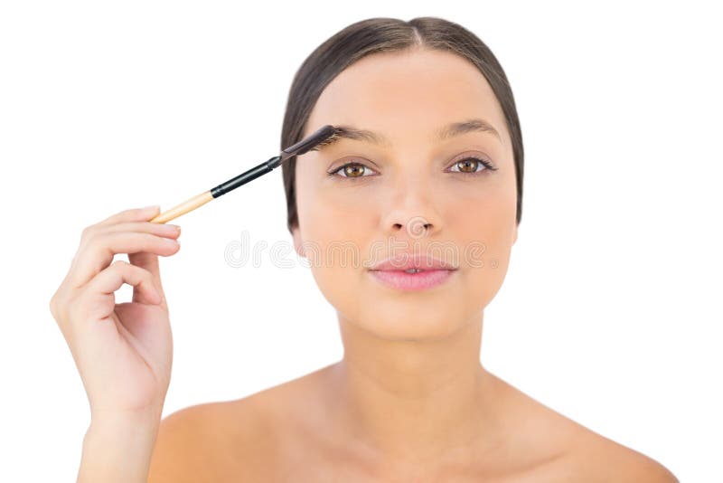 Donna che spazzola il suo sopracciglio immagini stock Donna che spazzola il suo sopracciglio immagini stock
