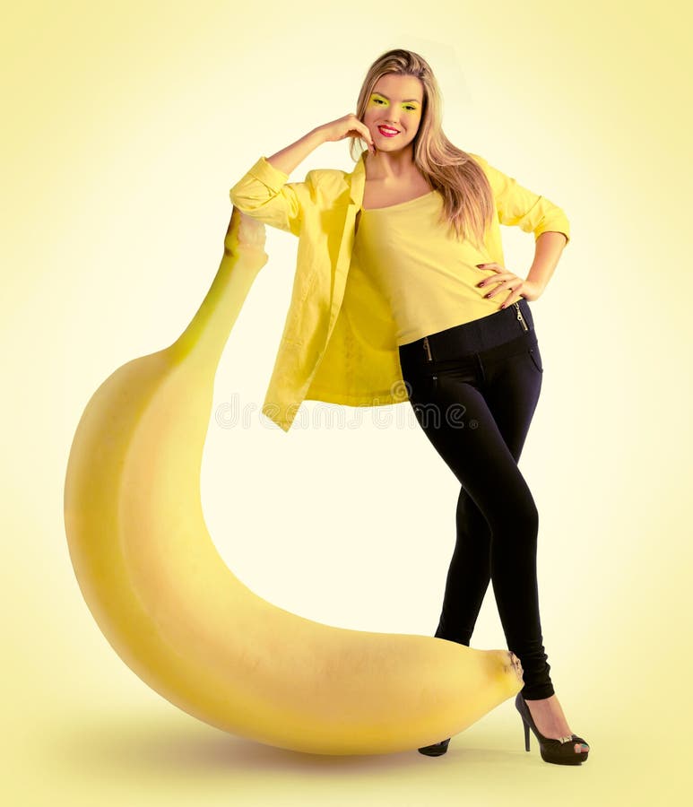Donna che sta accanto ad una grande banana fotografia stock Donna che sta accanto ad una grande banana fotografia stock