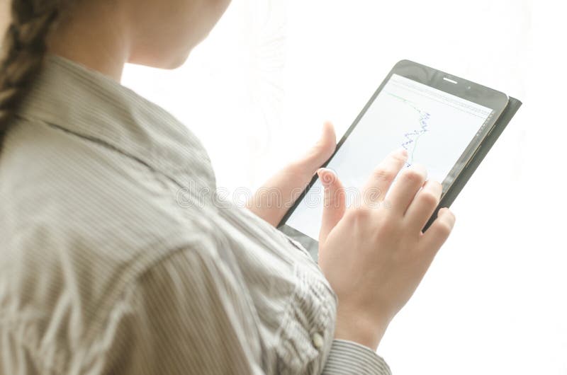 Slim woman standing at the window with a tablet. Slim woman standing at the window with a tablet