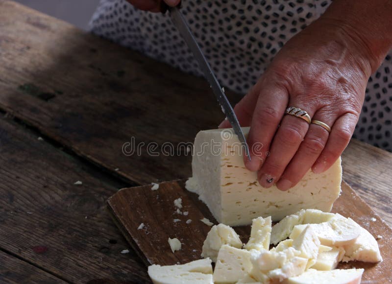 Donna che taglia formaggio fresco in piccole parti fotografia stock libera da diritti Donna che taglia formaggio fresco in piccole parti fotografia stock libera da diritti