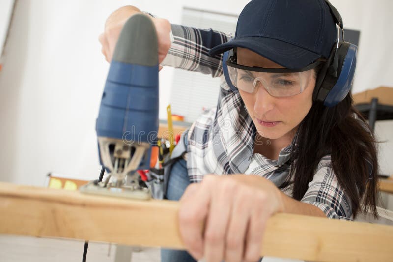 Donna che taglia legna per la costruzione immagini stock