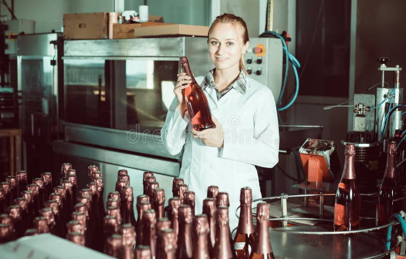 Donna che tiene le bottiglie di vino recentemente prodotte immagini stock Donna che tiene le bottiglie di vino recentemente prodotte immagini stock