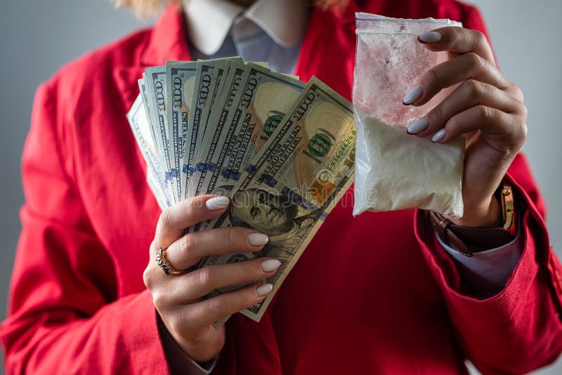 woman holding a hundred dollar bill for each dose of cocaine heroin or other drug and drugs in a bag. drugs and dollars. woman holding a hundred dollar bill for each dose of cocaine heroin or other drug and drugs in a bag. drugs and dollars.