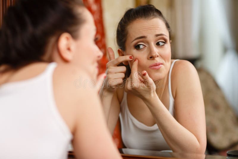 Donna che trova un'acne sulla sua guancia
