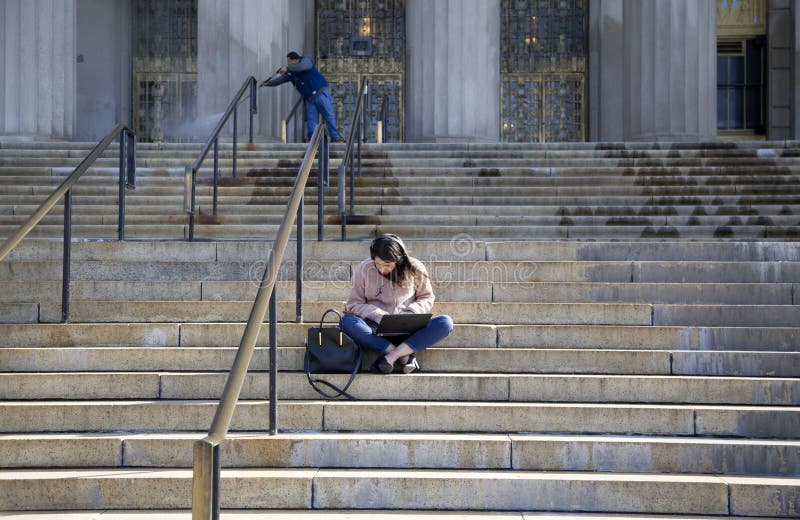 Donna che usa il portatile mentre siede a passi del tribunale della contea di Bronx fotografie stock libere da diritti Donna che usa il portatile mentre siede a passi del tribunale della contea di Bronx fotografie stock libere da diritti