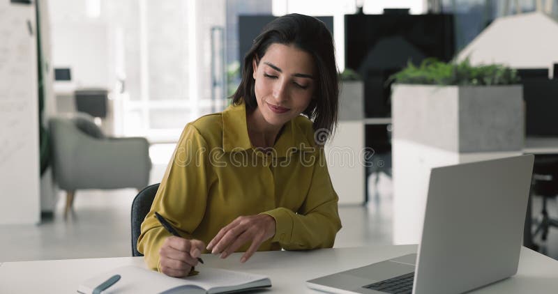 Donna che usa un portatile e scrive note in un organizzatore personale archivi video