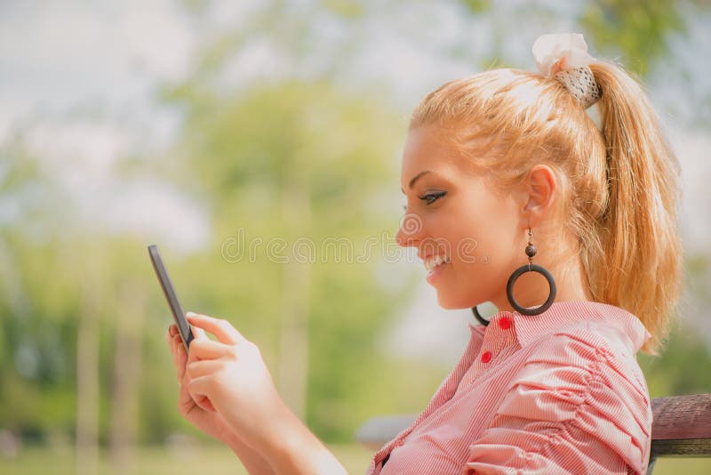 Donna che utilizza compressa digitale nel parco immagini stock