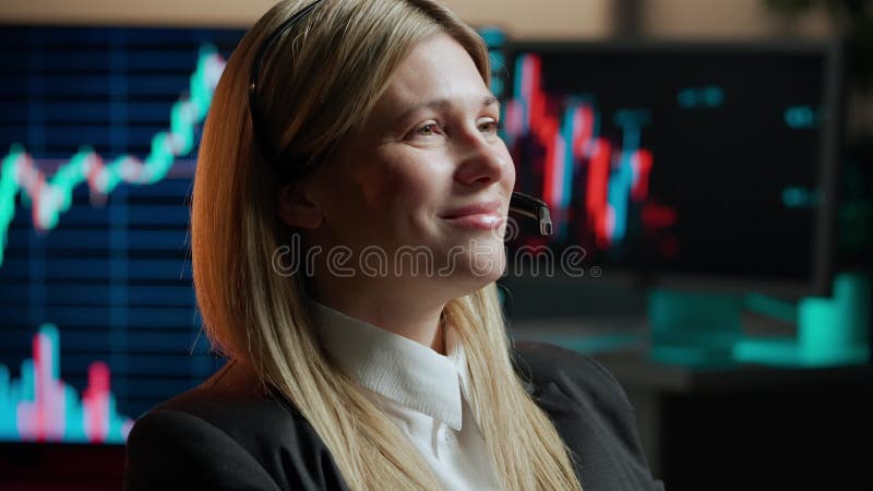 Donna commerciante di azioni lavora presso l'ufficio di intermediazione. computer e grandi schermi digitali in background.