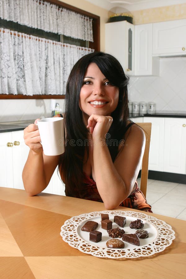 A woman indulges in coffee and decadent chocolate truffles. A woman indulges in coffee and decadent chocolate truffles