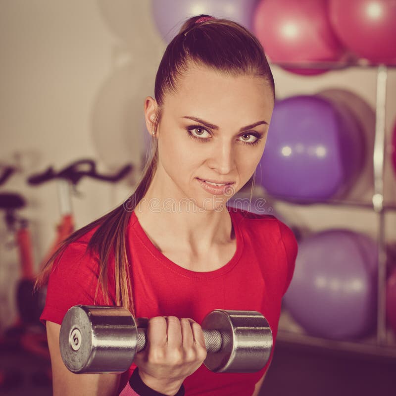 Donna con i dumbbellis nella palestra fotografia stock Donna con i dumbbellis nella palestra fotografia stock