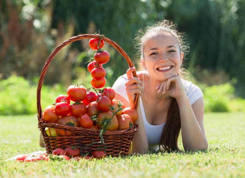 Donna con il raccolto del pomodoro in giardino