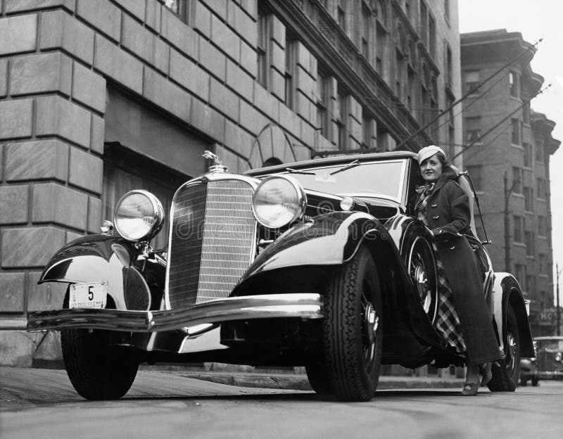 Donna con l'automobile sulla via della città (tutte le persone rappresentate non sono vivente più lungo e nessuna proprietà esist immagine stock Donna con l'automobile sulla via della città (tutte le persone rappresentate non sono vivente più lungo e nessuna proprietà esist immagine stock