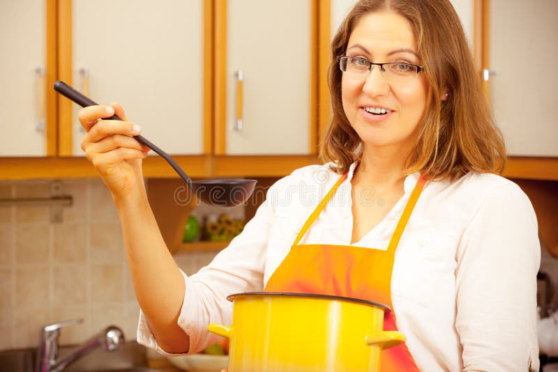 Donna con la siviera ed il vaso in cucina immagini stock libere da diritti Donna con la siviera ed il vaso in cucina immagini stock libere da diritti