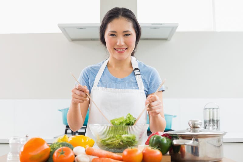 Donna con le verdure nella ciotola alla cucina immagini stock Donna con le verdure nella ciotola alla cucina immagini stock