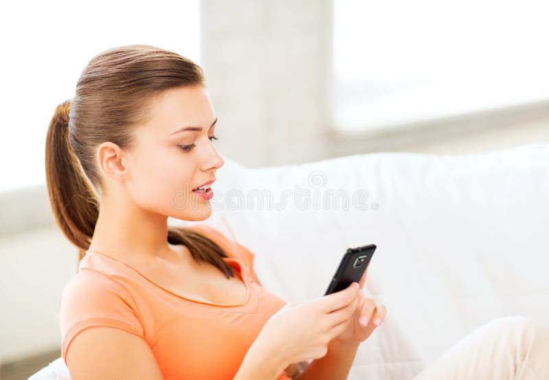 Donna con smartphone a casa immagine stock