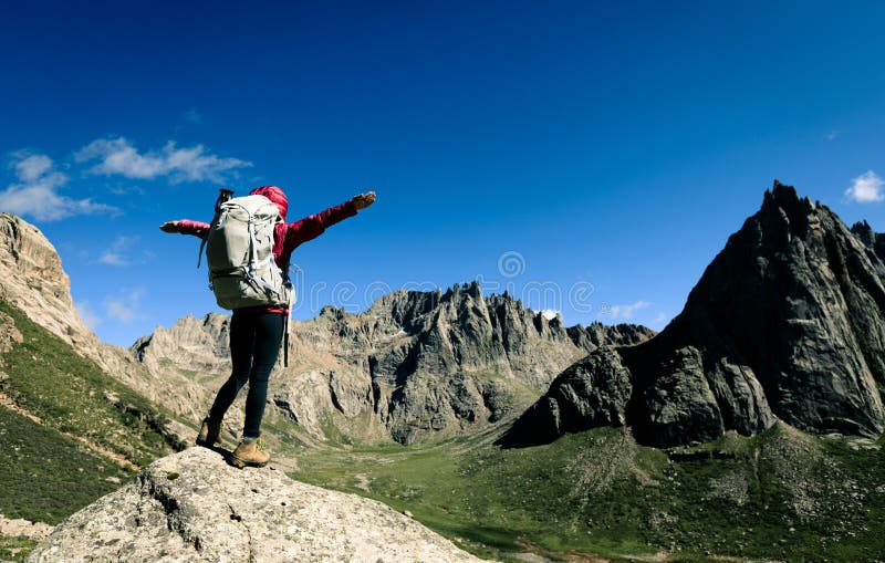 donna con lo zaino che fa un'escursione sulla cima della montagna di elevata altitudine