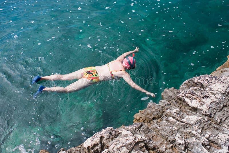 Donna con navigare usando una presa d'aria nel mare fotografia stock Donna con navigare usando una presa d'aria nel mare fotografia stock