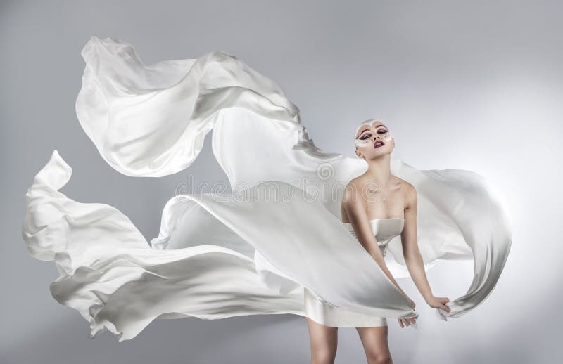Donna con trucco creativo luminoso in un volo bianco del panno fotografie stock libere da diritti Donna con trucco creativo luminoso in un volo bianco del panno fotografie stock libere da diritti