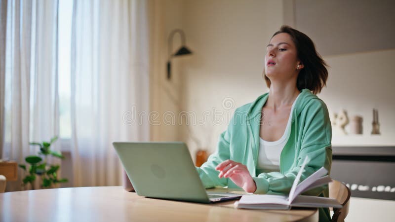 Donna concentrata che scrive laptop alla home desk con opuscolo. seria ricerca femminile archivi video