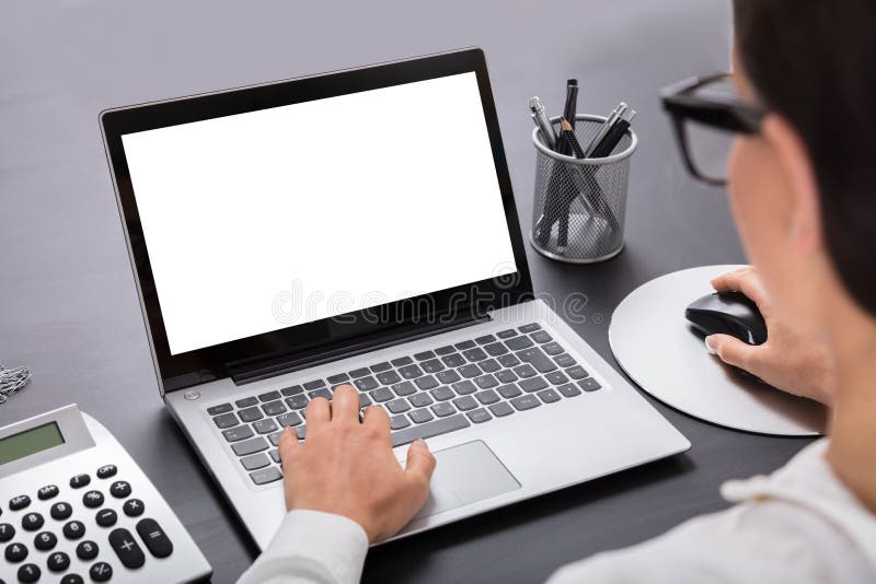 Donna d'affari che utilizza un portatile sulla scrivania fotografie stock