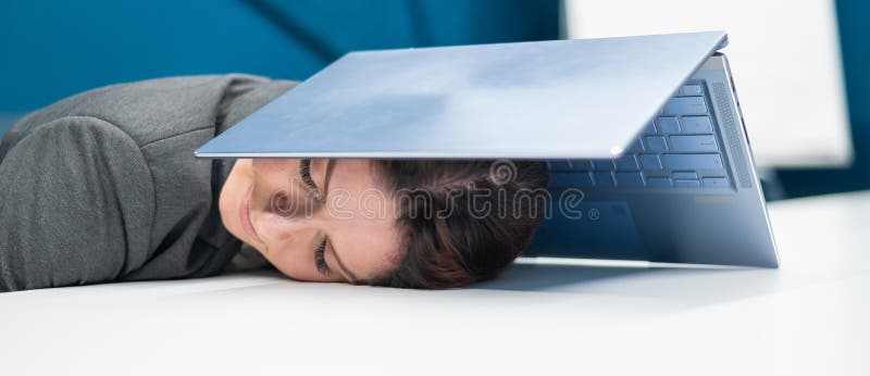Donna d'affari esausta che ha la testa coperta di un portatile. lavoratrice stanca con un computer sopra la testa. fotografia stock libera da diritti