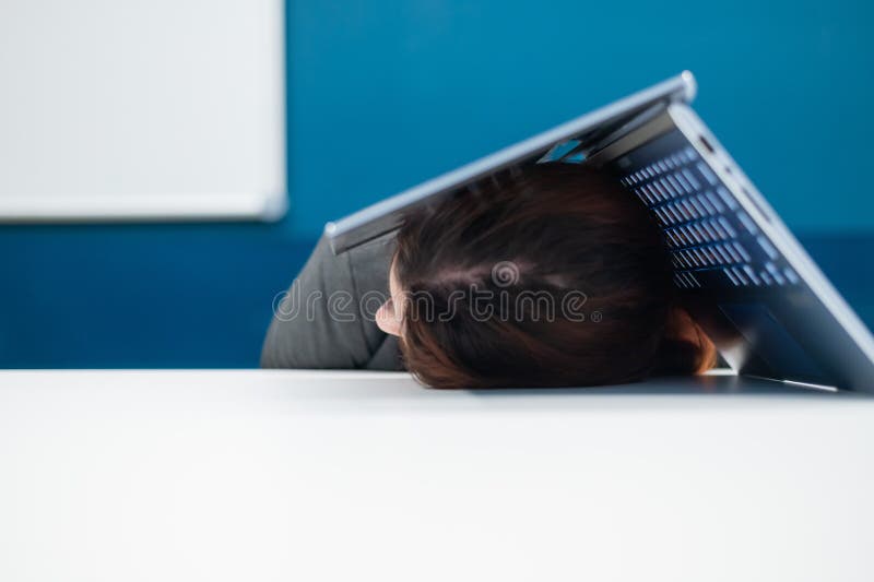 Donna d'affari esausta che ha la testa coperta di un portatile. lavoratrice stanca con un computer sopra la testa. fotografie stock