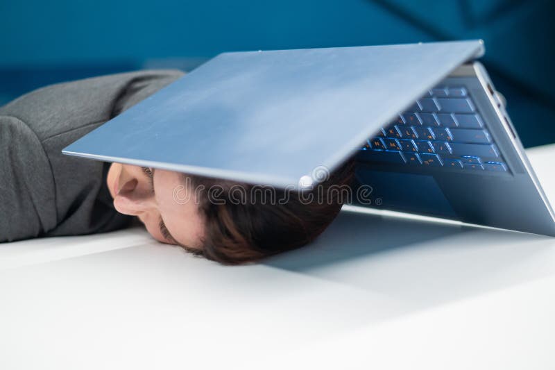 Donna d'affari esausta che ha la testa coperta di un portatile. lavoratrice stanca con un computer sopra la testa. immagine stock libera da diritti