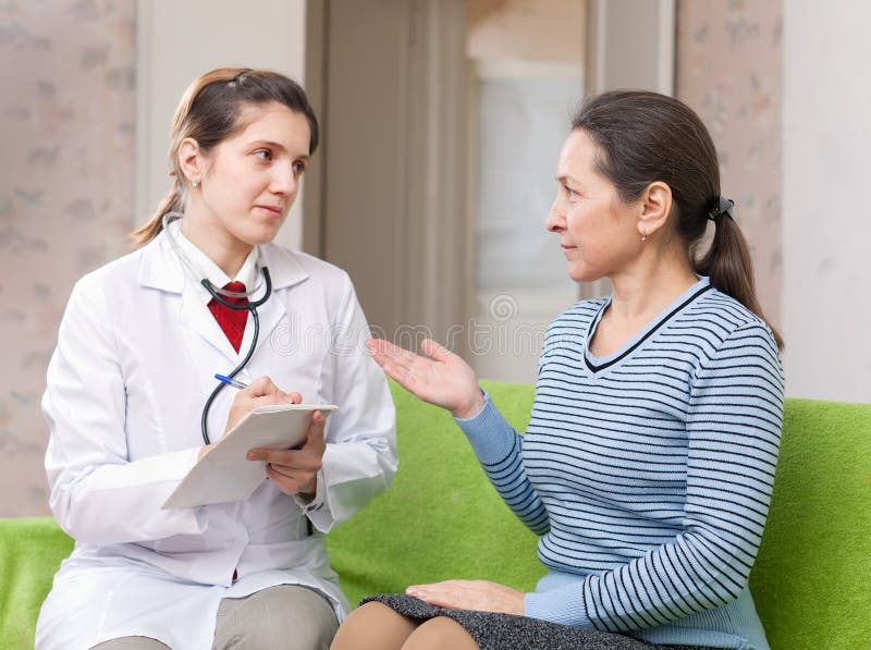 Donna d'esame di medico serio fotografia stock Donna d'esame di medico serio fotografia stock