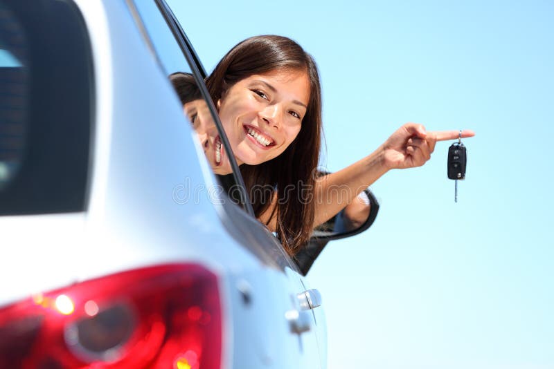 Donna del driver che mostra i nuovi tasti dell'automobile fotografia stock Donna del driver che mostra i nuovi tasti dell'automobile fotografia stock