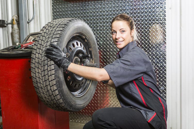 Donna del meccanico che lavora all'automobile nel suo negozio fotografie stock libere da diritti Donna del meccanico che lavora all'automobile nel suo negozio fotografie stock libere da diritti
