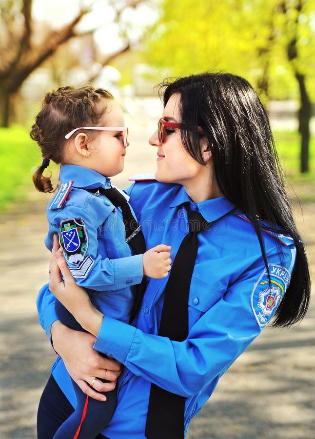 Donna della polizia con sua figlia immagini stock Donna della polizia con sua figlia immagini stock