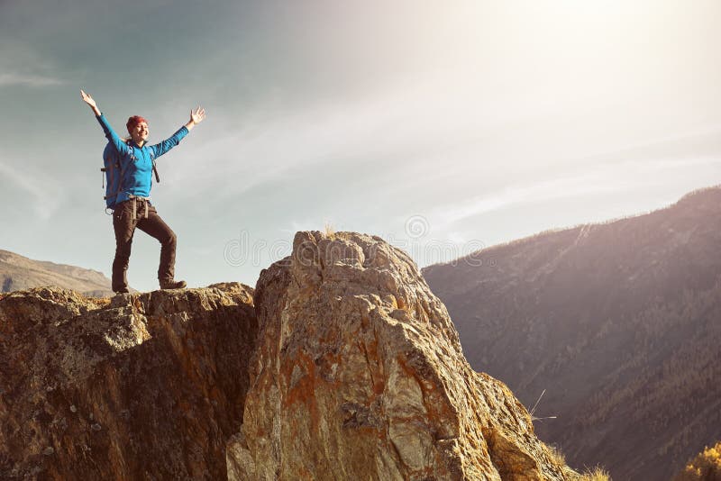 Donna della viandante con lo zaino che sta sopra una montagna con le mani sollevate fotografie stock libere da diritti Donna della viandante con lo zaino che sta sopra una montagna con le mani sollevate fotografie stock libere da diritti