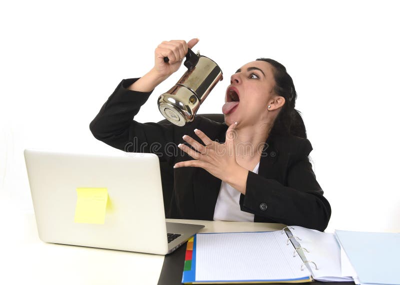 Donna di affari al caffè bevente dello scrittorio del computer portatile eccitato ed ansioso nella dipendenza della caffeina